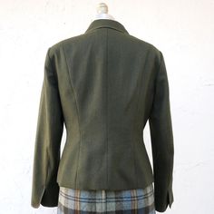 Olive green wool fitted blazer jacket with long sleeves and metal buttons down the front. It is lined and has two front pockets. Size 4 Measurements with room for comfort: Bust up to: 34 1/2 inches Waist up to: 28 inches Exact measurements taken flat to compare to a garment which fits well: Length: 21 1/2 inches Sleeve length: 22 inches Shoulders across the back: 15 1/2 inches Bust: 18 inches Waist: 15 1/2 inches Designer/ Brand/ Label Talbots Petite Condition is excellent The skirt is listed he Tailored Winter Tweed Button-up Jacket, Tailored Button-up Tweed Jacket For Winter, Fitted Button-up Tweed Jacket For Fall, Fall Blazer With Button Closure For Tailoring, Green Wool Sport Coat For Work, Green Fitted Sport Coat With Lapel Collar, Fitted Green Sport Coat With Lapel Collar, Green Tailored Outerwear With Lapel Collar, Green Tweed Jacket For Fall Workwear