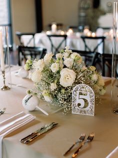 the table is set with silverware, flowers and candles for an elegant wedding reception