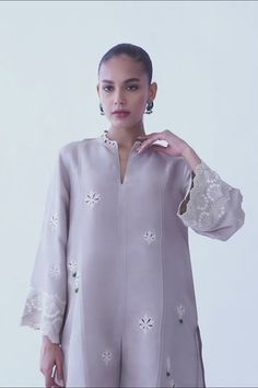 A beautifully crafted silver rawsilk fabric with floral eyelet detailing and embroidered sleeves. The look is completed with matching co-ord izaar with embroidered hem. Silk Dress With Embroidered Long Sleeves, Silk Long Sleeve Dress With Embroidered Sleeves, Spring Raw Silk Kurta With Floral Embroidery, Spring Kurta With Floral Embroidery In Raw Silk, Silk Kurta With Floral Embroidery For Spring, Spring Silk Kurta With Floral Embroidery, Spring Floral Embroidered Straight Kurta Top, Traditional Spring Kurta With Set-in Sleeves, Silk Embroidered Dress With Floral Design For Eid