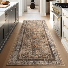 a large rug in the middle of a kitchen with an oven and counter tops on both sides