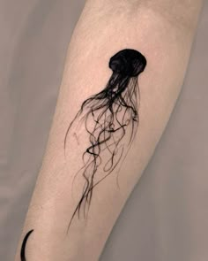 a black and white jellyfish tattoo on the leg