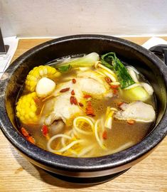 a bowl filled with soup sitting on top of a wooden table