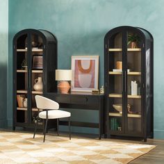 a room with two black bookcases and a white chair in front of it