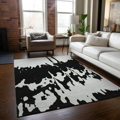 a living room with white couches and black and white rugs on the floor