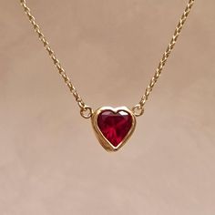 9ct solid gold ruby heart necklace. An ethical lab grown red ruby heart set in a recycled 9ct gold bezel setting.  Lab grown gemstones have the exact same composition as the natural gemstone except that they are more ethical choice due to being made in a lab as opposed to mined.  Self love, or for a loved one, this blood red heart necklace is the perfect gift to say I ❤️ you Dimensions:  Ruby size 6mm Pendant size about 1cm Chain length: Available in 16", 18" and 20". Please choose your required length in the drop down menu Dispatch times: Each piece is handcrafted specifically for you so please allow upto 2 weeks for dispatch. Rush order: If item is needed within 2 weeks please send a message before purchase. We charge a £5 rush order fee. Please also choose special delivery at checkout. Ruby Heart Necklace, Ruby Heart Pendant, Gold Ruby Necklace, Red Heart Necklace, Necklace Ruby, Ruby Heart, Book Edits, Ruby Necklace, Necklace Heart