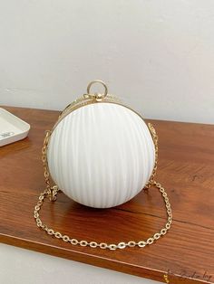 a white purse sitting on top of a wooden table