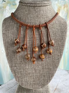 Beautiful Copper, Gold, Sienna Brown Crackled Agate Glass beads. I love the fun casual boho look of this necklace. I chose a  distressed sienna brown thick leather cording for the base.  There are 5 double strands of leather attached to create dangles for the beautiful agate beads. The beads are unique in the design and multiple colors you will see.  They are an opaque glass with a crackled look. The colors include sienna brown to match the leather. You will also see copper, gold, tan, and taupe Rustic Adjustable Jewelry With Large Beads, Bohemian Brown Necklace With Adjustable Length, Hippie Brown Jewelry With Natural Stones, Earthy Adjustable Necklace With Large Beads, Earthy Style Adjustable Necklace With Large Beads, Brown Necklace With Adjustable Cord For Festivals, Earthy Necklace With Large Adjustable Beads, Rustic Adjustable Beaded Necklaces, Brown Bohemian Jewelry With Adjustable Length