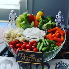 a bowl filled with veggies and star wars figurines on top of a table