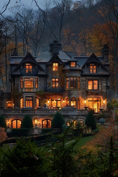 a large house lit up at night in the woods