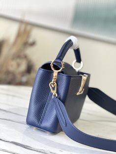 Dark blue and mother-of-pearl mini This Capucines medium-sized handbag is made of full-grain Taurillon leather, which makes the logo like jewelry shine like malachite. It injects grace into the classic design. The wide leather shoulder strap is suitable for shoulder or cross-body Handle dexterously shuttle in day and night occasions.

Size: 21 * 14 * 8 cm Designer Shoulder Bag With Handle Drop As Gift, Small Elegant Shoulder Bag With Dust Bag, Small Elegant Shoulder Bag, Small Elegant Shoulder Bag For Daily Use, Elegant Small Shoulder Bag For Daily Use, Small Luxury Evening Bag, Small Luxury Evening Bags, Small Designer Bag With Dust Bag Included, Luxury Small Bags For Everyday Use