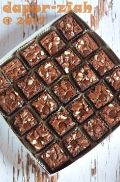 chocolate brownies with almonds in a pan on a white wooden table and text overlay