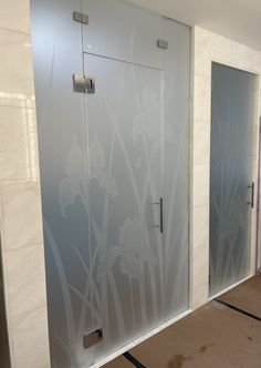 two glass doors with flowers etched on them in a room that is being painted white