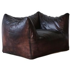 a brown leather bean bag chair sitting on top of a white floor