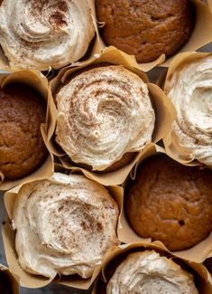 several cupcakes with frosting in paper cups