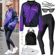 a woman in purple jacket and black leggings walking down the street with white sneakers