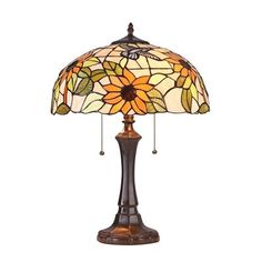 a table lamp with a sunflower design on the base and a glass shade over it