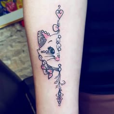 a small tattoo on the leg of a woman with a cat and heart decoration around it