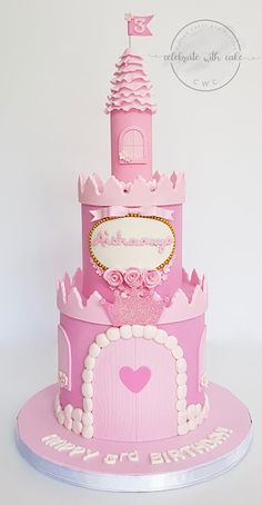 a pink princess castle cake with white frosting on it's top and bottom tier