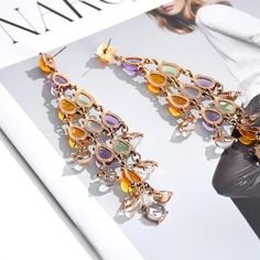 Mesmerizing, Romantic, Distinctive – Introducing the Elegant Crystal Tassel Drop Earrings, a true masterpiece of design and elegance. These long statement earrings feature colourful transparent resin crystals arranged in a stunning tassel structure that lets light shine through, creating a captivating effect. With their glass-like ornaments and elegant length, these earrings are perfect for adding a touch of romance and sophistication to any outfit. Why We Love It... The Elegant Crystal Tassel D Multicolor Crystal Chandelier Drop Earrings, Multicolor Crystal Chandelier Earrings, Elegant Multicolor Crystal Earrings For Evening, Elegant Multicolor Dangle Crystal Earrings, Elegant Multicolor Crystal Earrings, Elegant Multicolor Drop Tassel Earrings, Elegant Multicolor Tassel Drop Earrings, Elegant Multicolor Tassel Earrings For Party, Elegant Multicolor Tassel Earrings For Gift