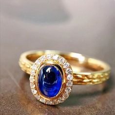 two yellow gold rings with blue and white stones