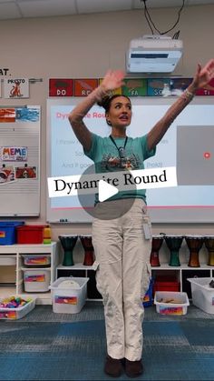 a woman standing in front of a whiteboard with her hands up to the side