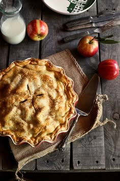 an apple pie sitting on top of a wooden table