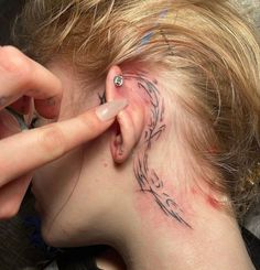 a woman has a tattoo on her ear