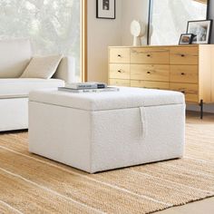 a white ottoman sitting on top of a rug in a living room