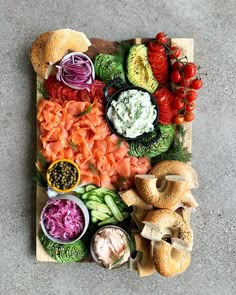 a wooden cutting board topped with different types of foods and vegetables on top of each other