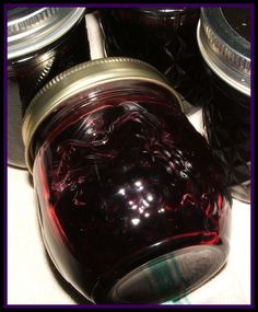 jars filled with red liquid sitting on top of a counter