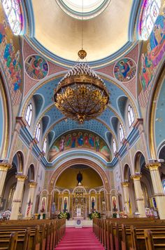 the inside of a church with red carpet and chandelier hanging from the ceiling