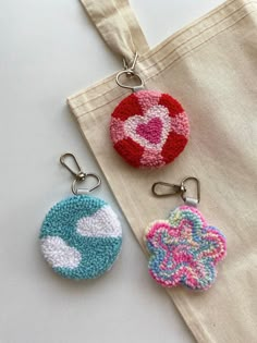 two crocheted key fobs sitting next to each other on a table