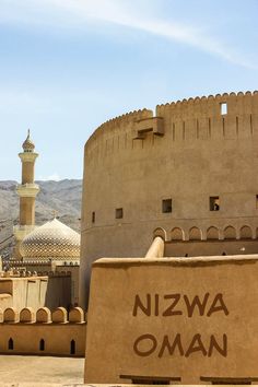 an old building with a sign in front of it that says nizwa oman