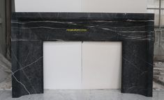 a black and white marble fireplace surround with gold lettering