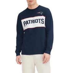 Upgrade your New England Patriots look with this Peter T-shirt. This Tommy Hilfiger tee features bold graphics and a classic design with a team wordmark across the chest. This soft cotton tee is a casual yet stylish choice for game day. Screen print graphics Brand: Tommy Hilfiger Imported Flatlock stitching Officially licensed Machine wash, tumble dry low Long sleeve Material: 100% Cotton Embroidered fabric applique Woven tag Fan Apparel Long Sleeve Relaxed Fit T-shirt, Long Sleeve Sports T-shirt With Team Logo, Long Sleeve T-shirt With Team Logo For Fan Gear, Collegiate Long Sleeve T-shirt For College, Long Sleeve T-shirt With Team Name For Fans, Cotton Long Sleeve T-shirt For Sports Events, Collegiate Long Sleeve T-shirt With Screen Print, Collegiate Long Sleeve Tops For Game Day, Collegiate Style Long Sleeve Tops For Game Day