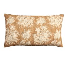 a brown and white pillow with flowers on it