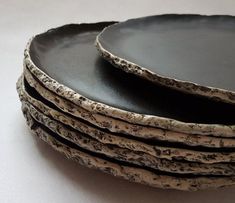 a stack of black plates sitting on top of a white table