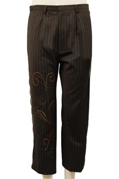 a mannequin wearing brown pinstripe pants with embroidered flowers on the side