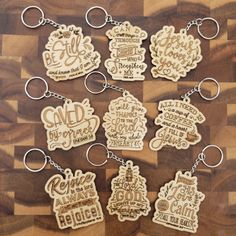 six wooden keychains with different words on them sitting on top of a table