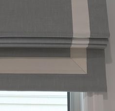 a window with roman blinds in grey and white