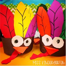 two turkeys made out of paper with eyes and leaves on their heads, sitting next to each other