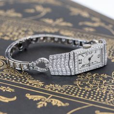 One of the most beautiful, blingy, and absolutely stunning cocktail watches that one could possibly add to one's jewelry suite! Made by the well-known jewelry house JE Caldwell, the watch is studded with antique diamonds, pave-set in platinum. The case is in excellent condition and has been observed to be running. The bracelet is in addition, styled beautifully to complement the case. The perfect accessory to complete any outfit! Platinum with a 14kt white gold bracelet Will fit up to a 6.25" wr Jewelry Suite, Modern Mens Rings, Art Jewelry Earrings, Art Deco Watch, Antique Watches, White Gold Bracelet, Antique Engagement, Antique Engagement Rings, Art Deco Diamond