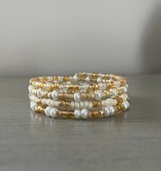 This memory wire bracelet with gold seed beads is a great option for bridal accessories or other special occasions. This bracelet wraps around the wrist giving the appearance of multiple bracelets, though it is one piece. Beads are glass and multi sized, but small making this low weight and comfortable.  Memory wire is flexible and strong. This bracelet measures 7 inches around but will stretch a bit to a bigger size. For small wrists, this will hang like a bangle. Bohemian Gold Hand-wrapped Beads, Bohemian Gold Hand Wrapped Beads, Gold Wrap Bracelet With Tiny Beads As A Gift, Gold Wrap Bracelet With Spacer Beads As Gift, Elegant Wrap Bracelet With Tiny Beads As A Gift, Elegant Wrap Bracelet With Tiny Beads For Gift, Bohemian Gold Wrap Bracelet With Tiny Beads, Dainty Hand-wrapped Gold Beaded Bracelets, Dainty Hand Wrapped Gold Beaded Bracelets