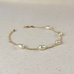 Indulge in the timeless beauty and sophistication of our 18k Gold Filled Spaced Baroque Pearl Bracelet. The perfect blend of elegance and delicacy, this classic piece exudes a luxurious charm that will elevate any outfit. Add a touch of opulence to your wardrobe and captivate with every turn of your wrist. Metal: 18k Gold Filled Width: 10mm Simulated Baroque Pearl Beads Size: 6.5 + 1 inch adjustment. Hypoallergenic Water-resistant Handcrafted in Brazil Formal White Gold Bracelets With Pearl Chain, Elegant Pearl Chain Bracelets For Wedding, Elegant Pearl Chain Bracelet For Anniversary, Elegant Gold Adjustable Bracelet For Formal Occasions, Formal Pearl Chain Bangle Bracelet, Elegant Adjustable Gold Bracelet For Formal Occasions, Elegant Wedding Bracelets With Pearl Chain, Elegant Pearl Drop Bracelet For Party, Elegant Pearl Bracelet For Party