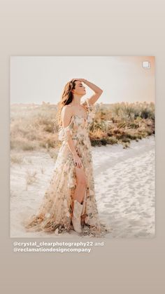 a woman standing in the sand wearing a dress