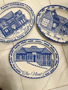 three blue and white plates sitting on top of a tile floor