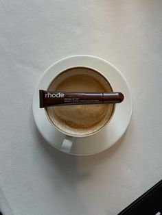 a cup of coffee with a chocolate stick sticking out of it