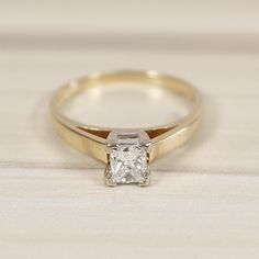 a yellow gold engagement ring with a princess cut diamond