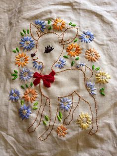 an embroidered piece of cloth with flowers and a horse on it