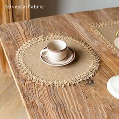 a wooden table topped with two white plates and a cup on top of each other